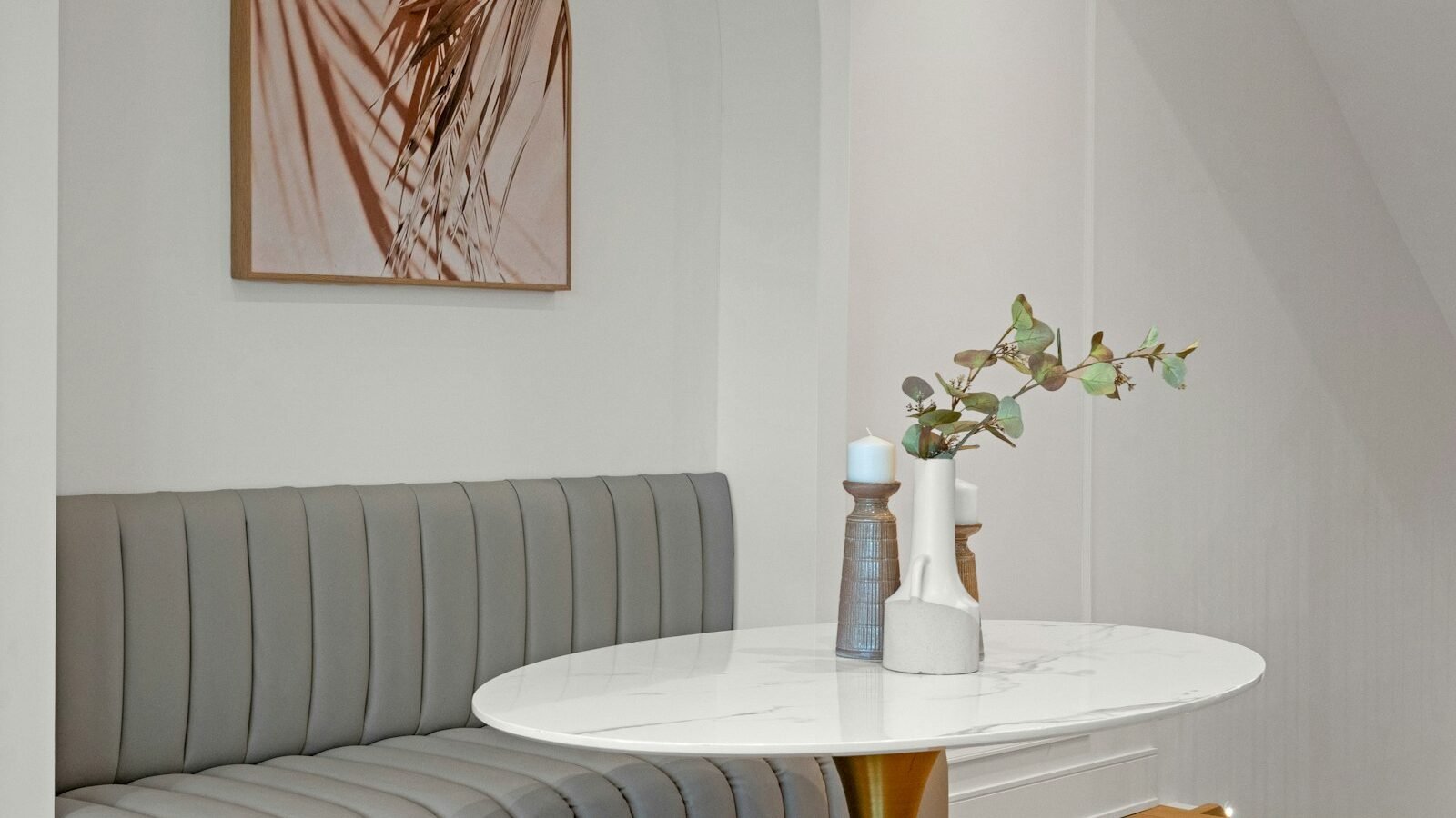 Grey banquette seating around a marble dining table