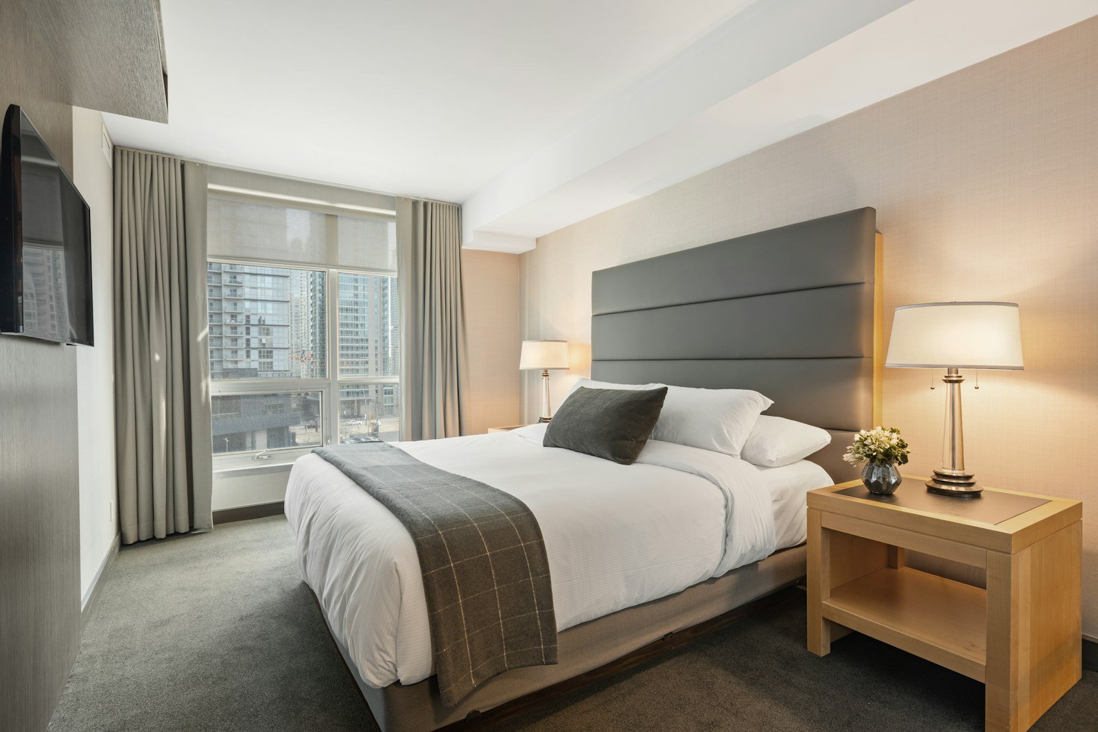 Double bed in a modern bedroom with a grey headboard and white bedding