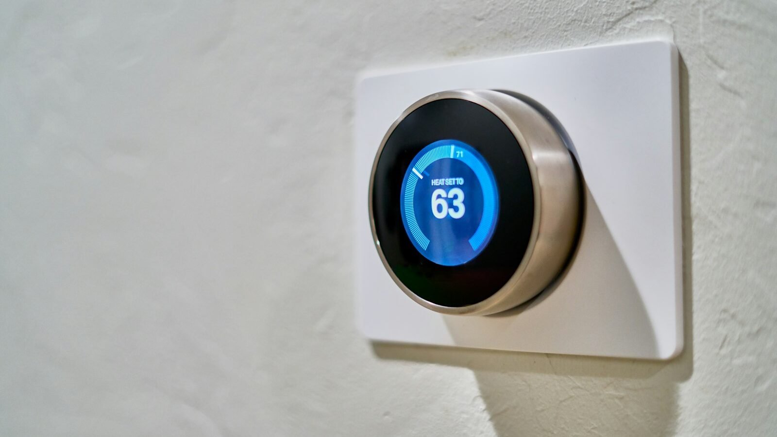 Modern smart thermostat mounted on a UK interior wall