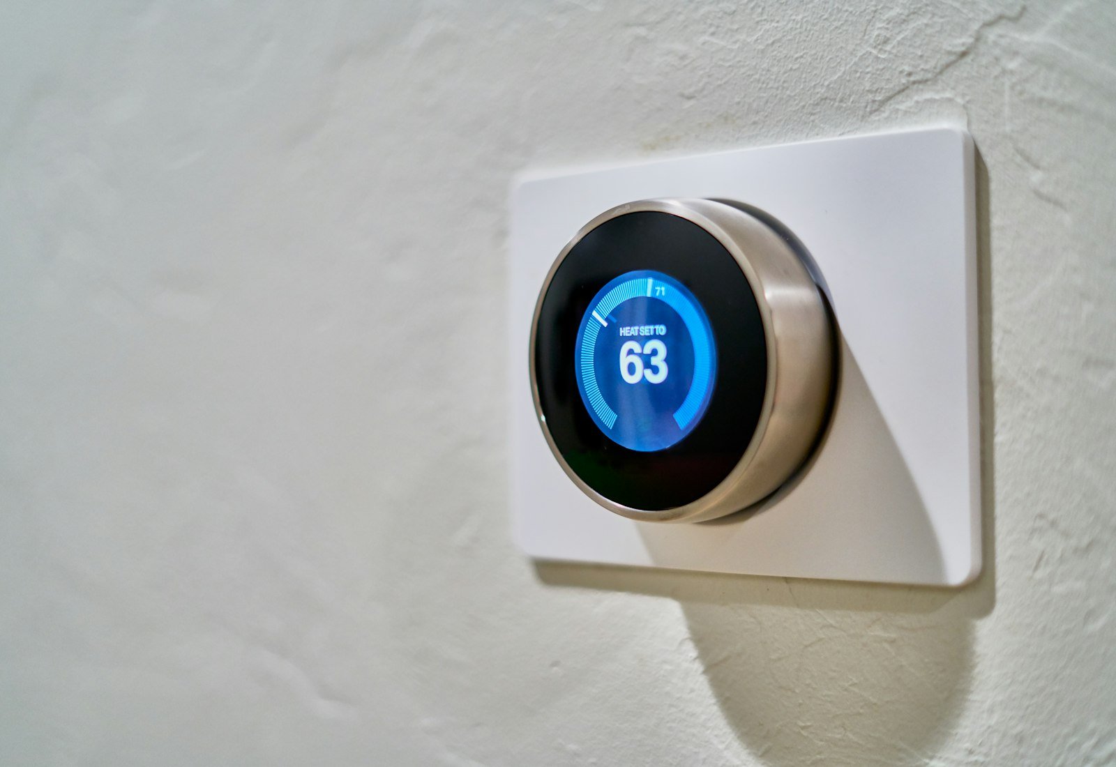 Modern smart thermostat mounted on a UK interior wall