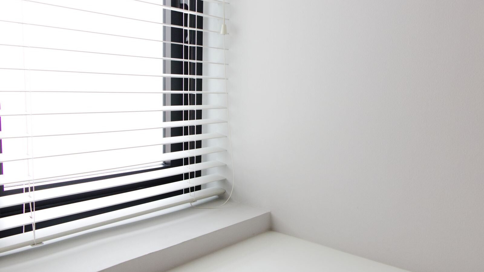White horizontal window blinds in a bright interior