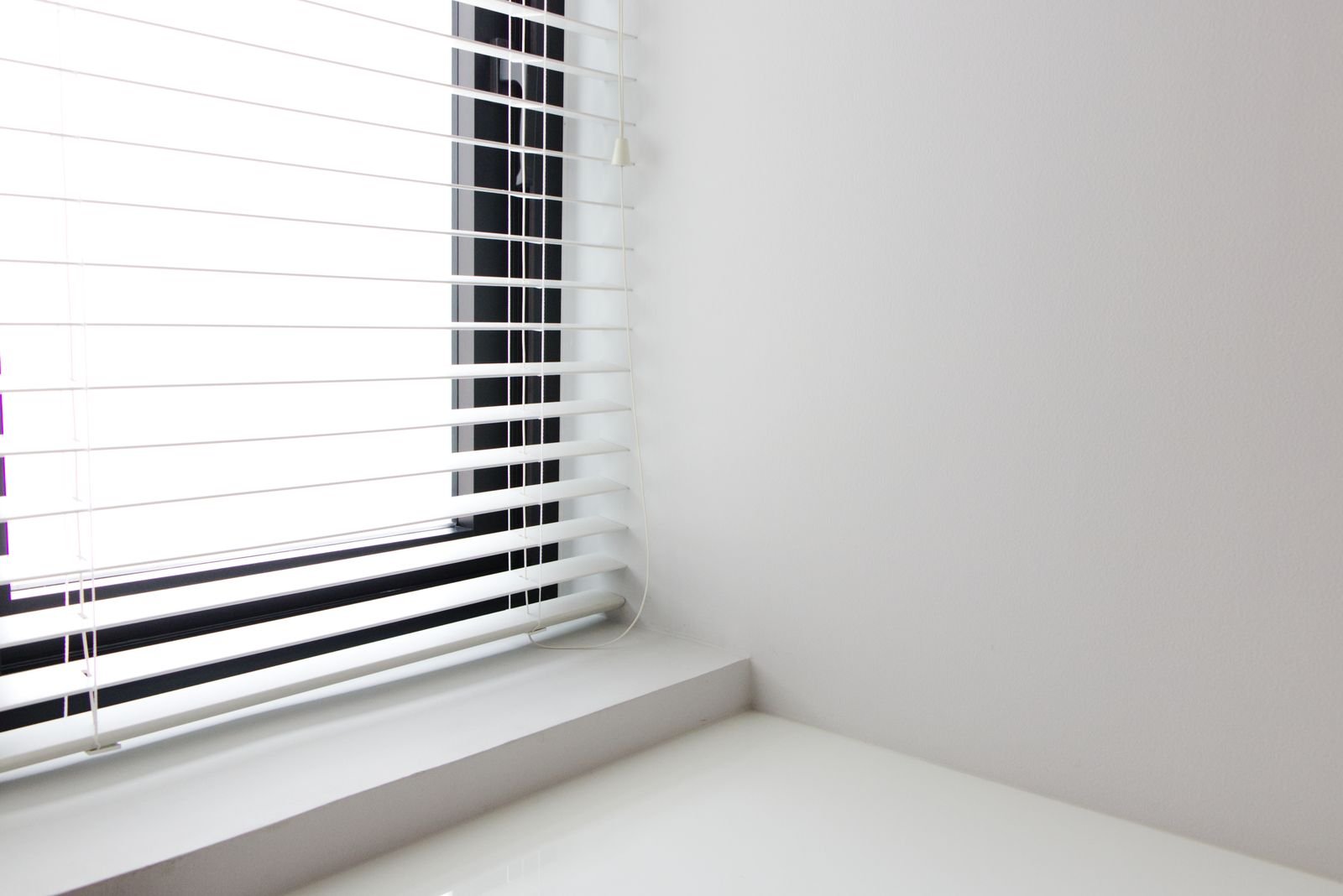 White horizontal window blinds in a bright interior