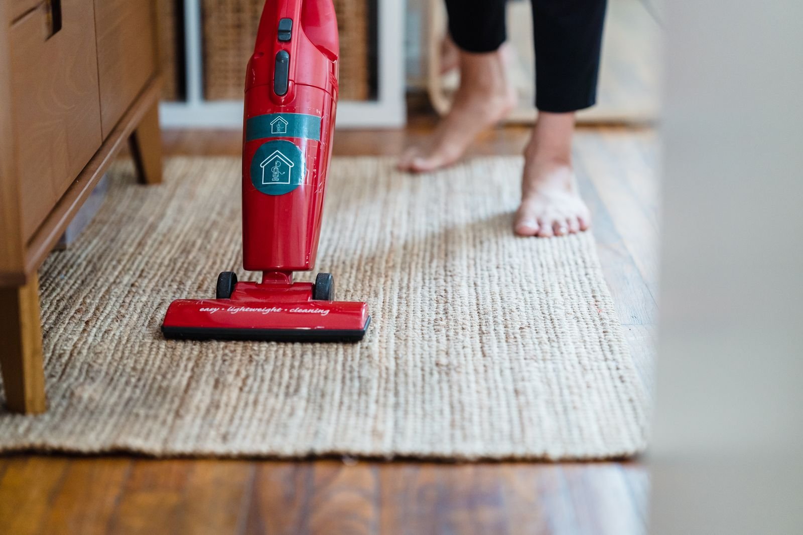 Red vacuum cleaner cleaning a carpet in a home
