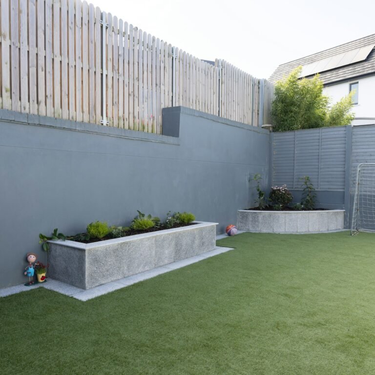 Back garden with lawn, planting beds and a paved seating area