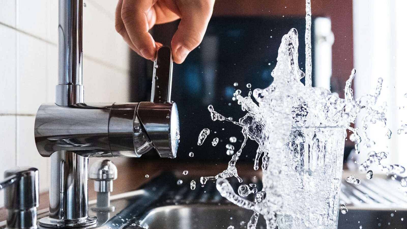Person checking a kitchen tap during a home plumbing repair