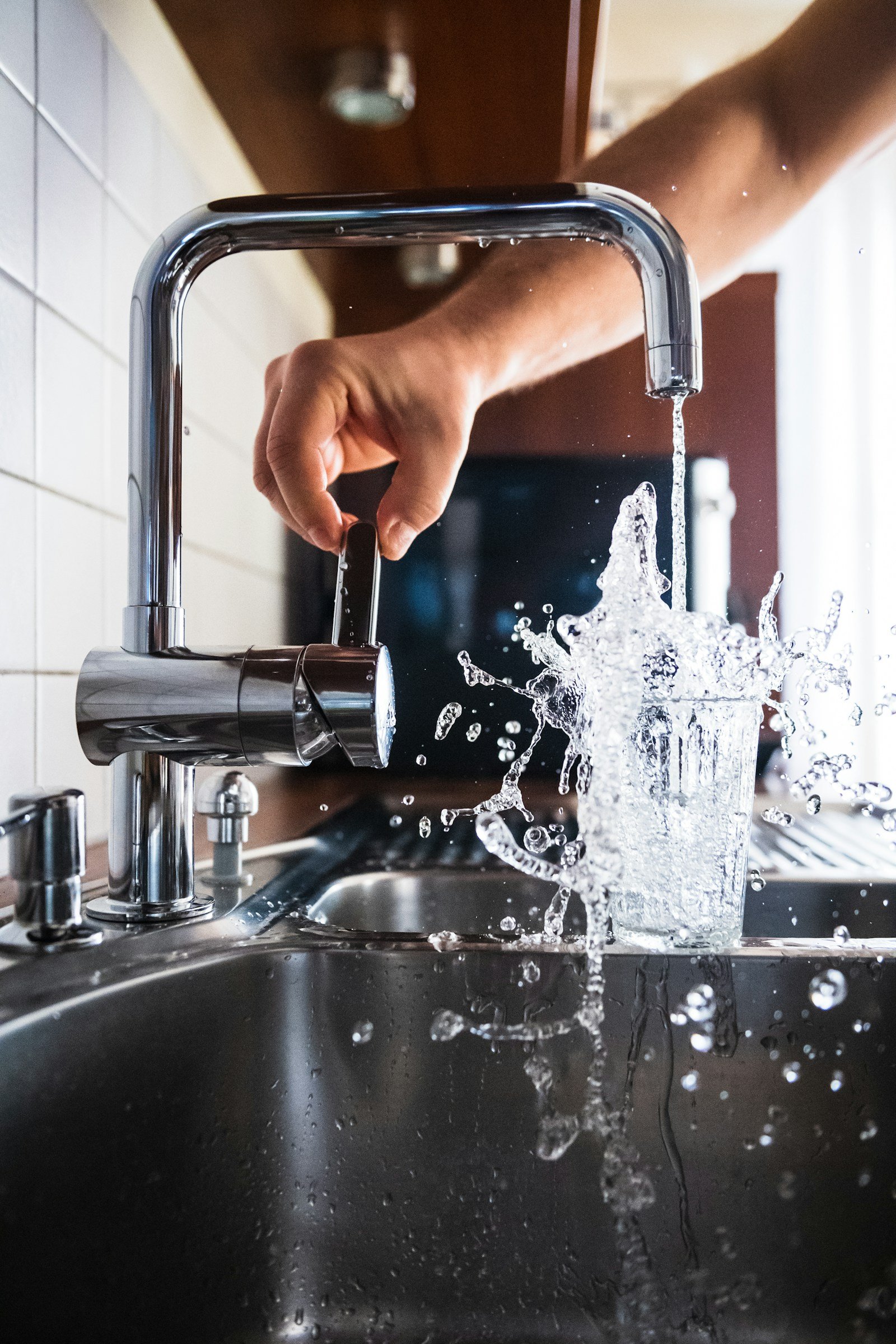 Person checking a kitchen tap during a home plumbing repair