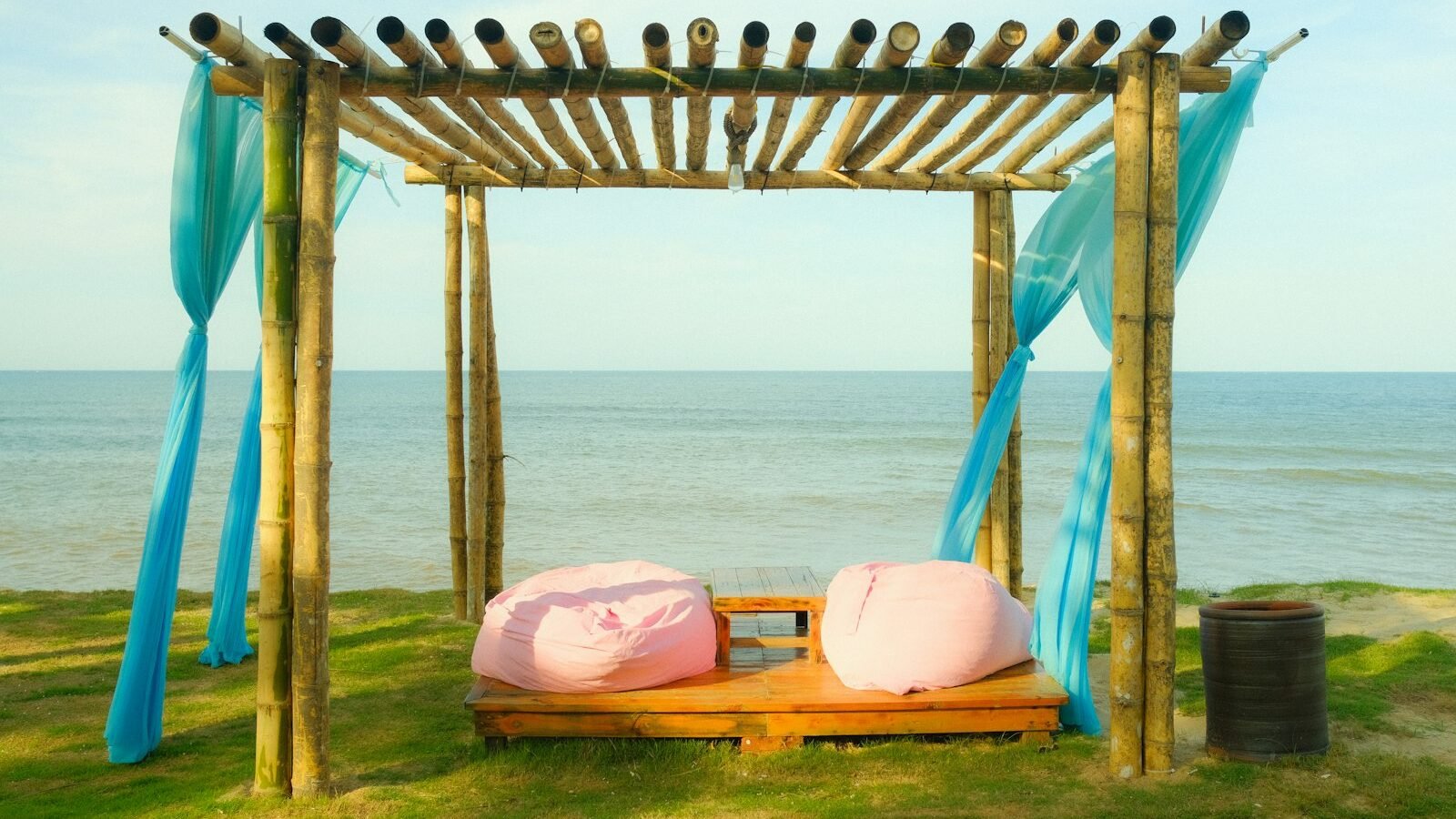 Pink outdoor bean bags on a wooden deck by the sea