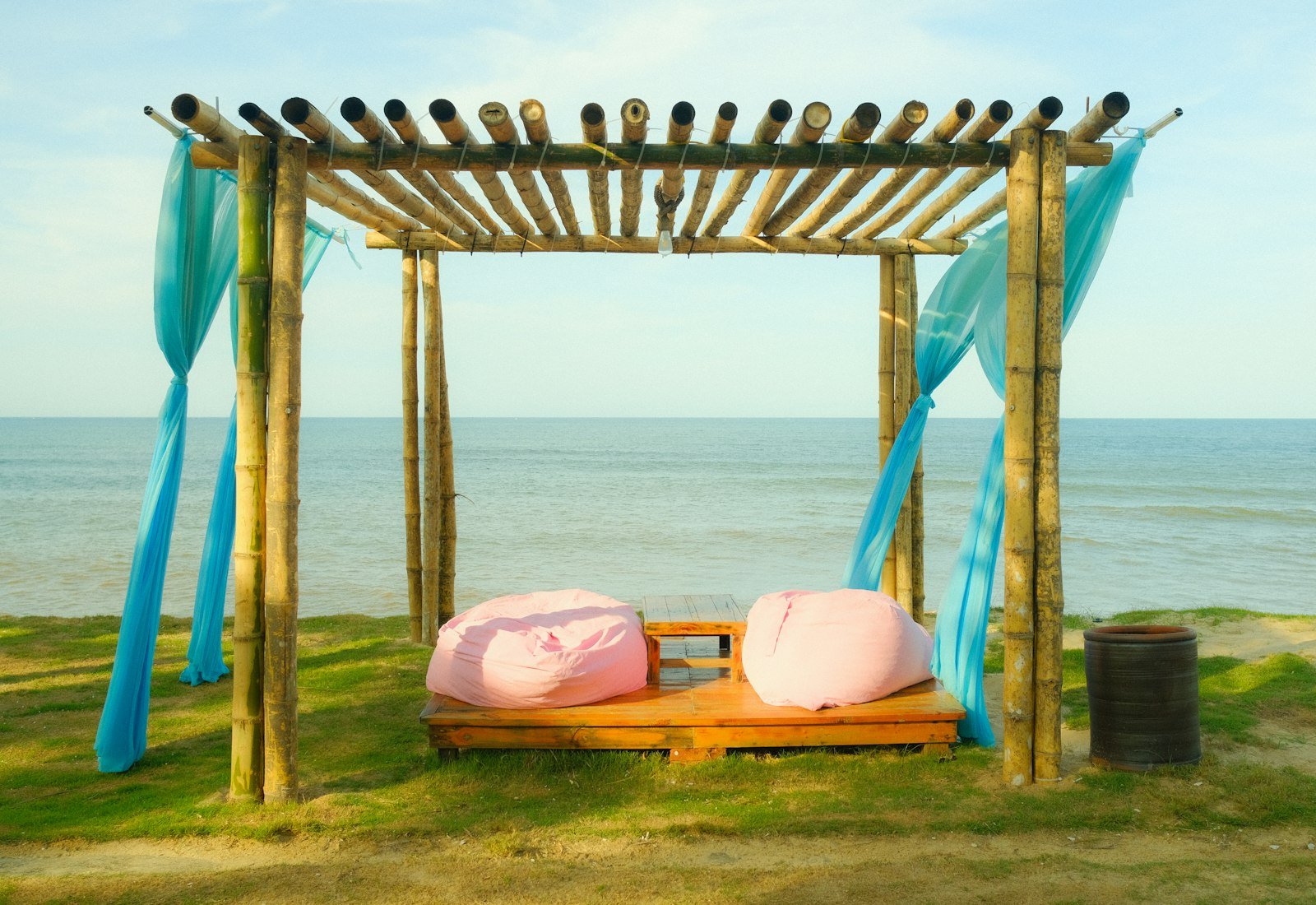 Pink outdoor bean bags on a wooden deck by the sea