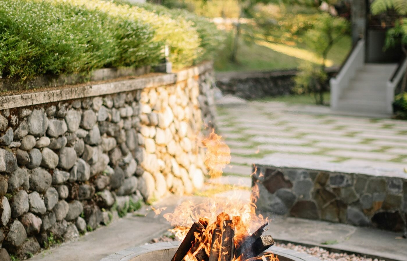 Wood-burning fire pit glowing in a garden patio