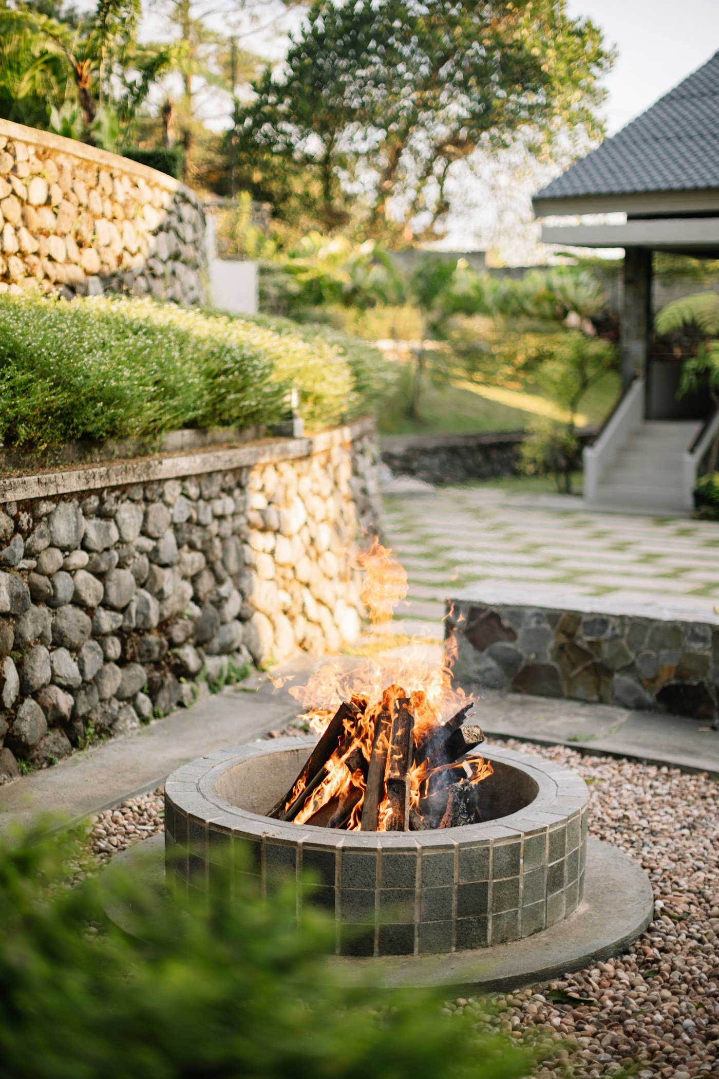 Wood-burning fire pit glowing in a garden patio