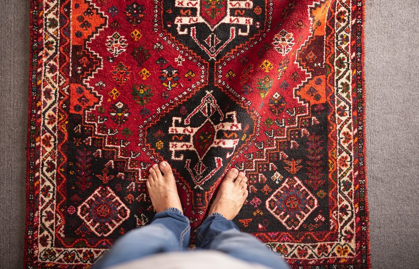 Person standing beside a rug in a furnished room