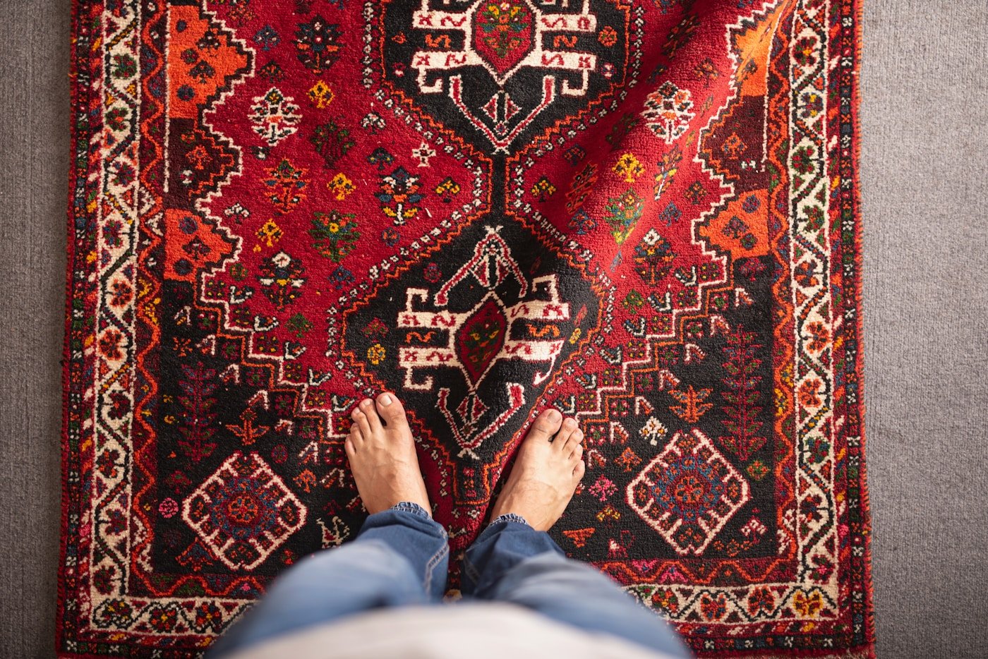 Person standing beside a rug in a furnished room