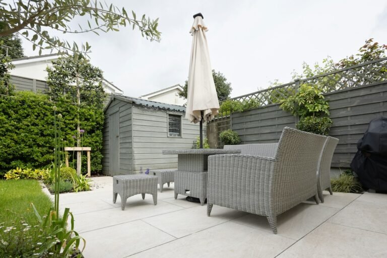 Low-maintenance patio garden with paved terrace, outdoor seating, and evergreen planting