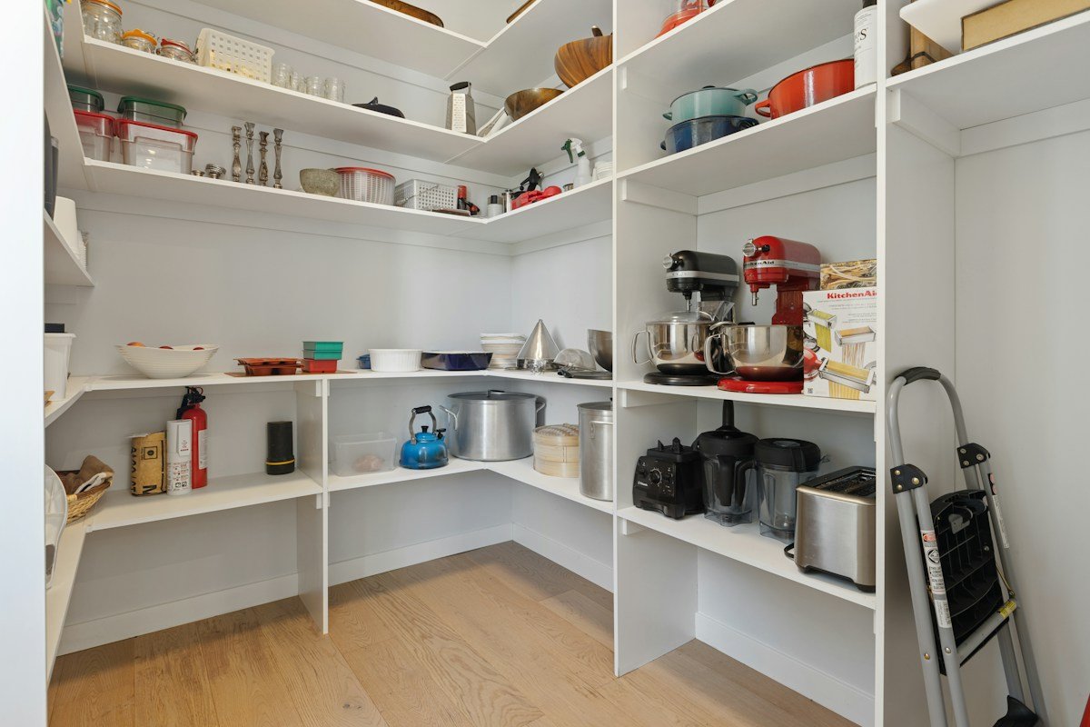 Bright walk-in pantry with open shelves, appliances, and organised storage