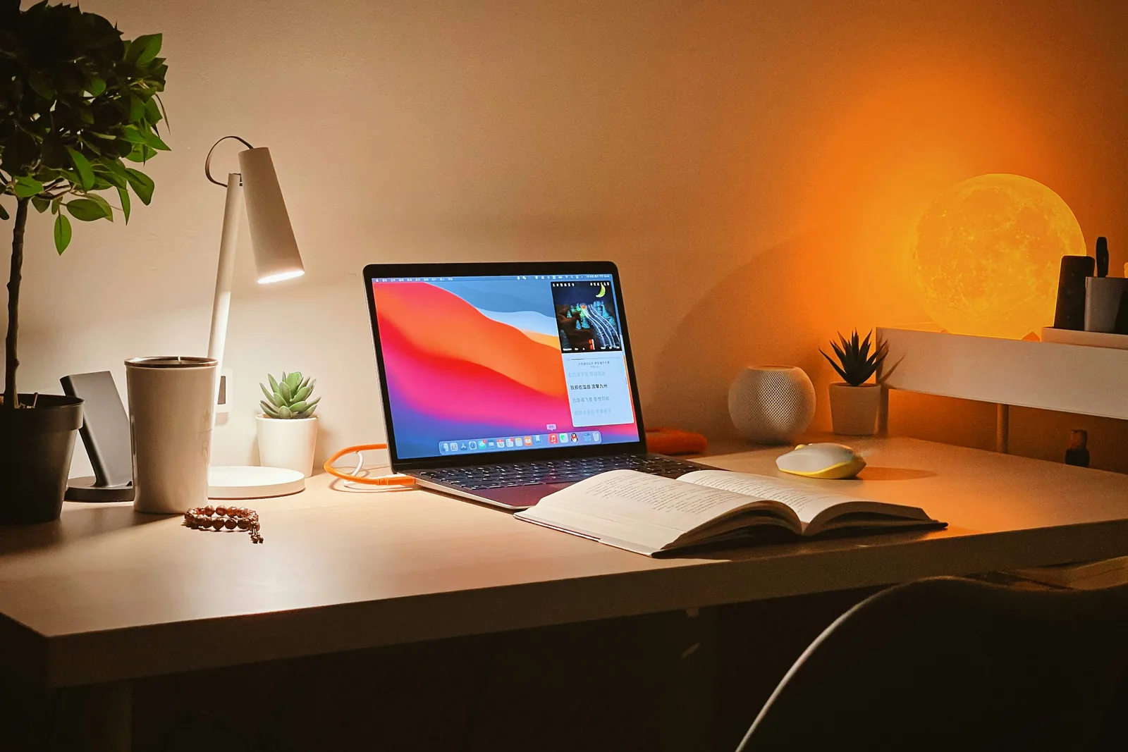 Laptop and notebook arranged on a warm wood study desk
