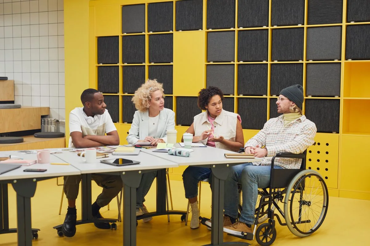 Colleagues, including a wheelchair user, meeting around a table