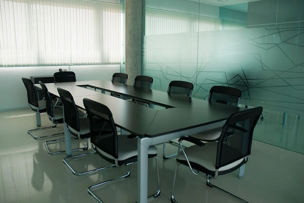 Meeting table and chairs in a glass-walled conference room