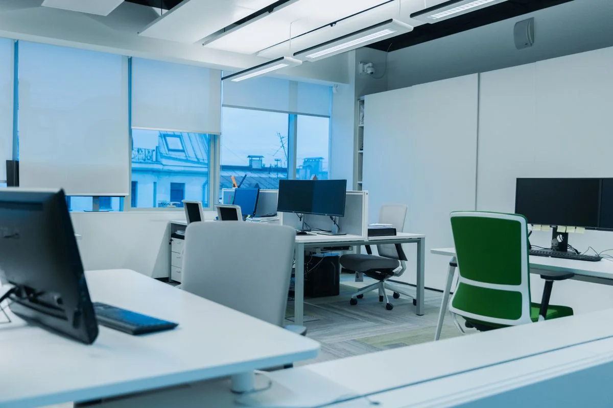Bright modern office workstations beside large windows