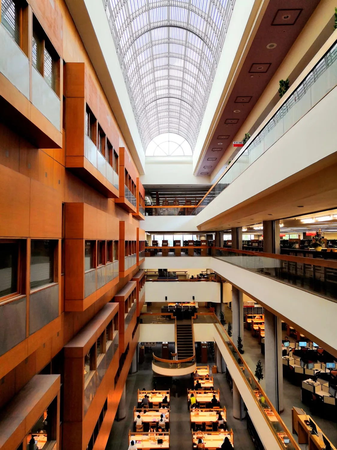 Multi-storey atrium with a glazed roof and shared balcony levels