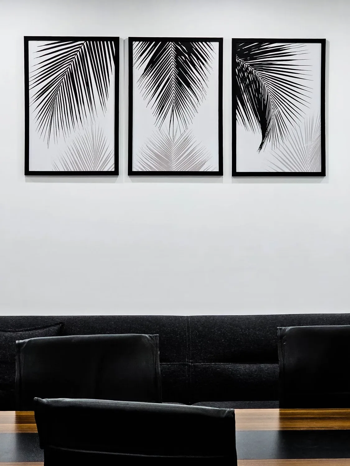 Lounge seating beneath framed prints in an office meeting area