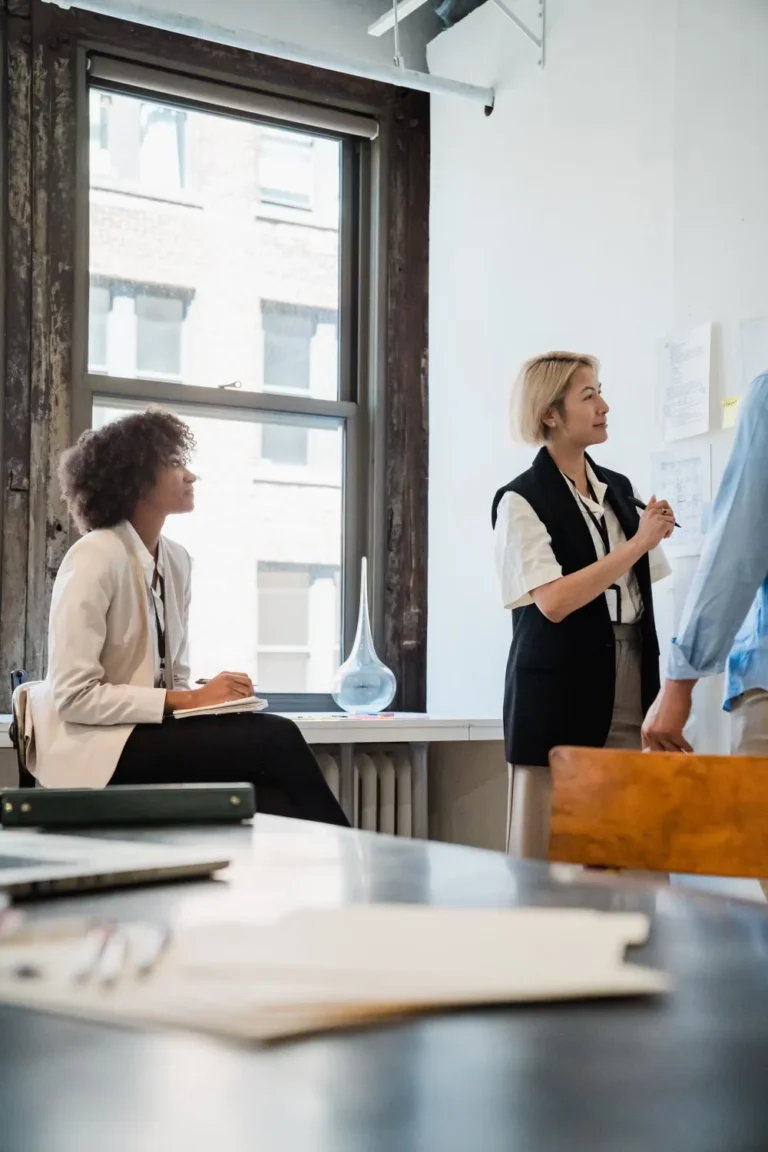 Colleagues planning corporate office interior design around a table in a bright office